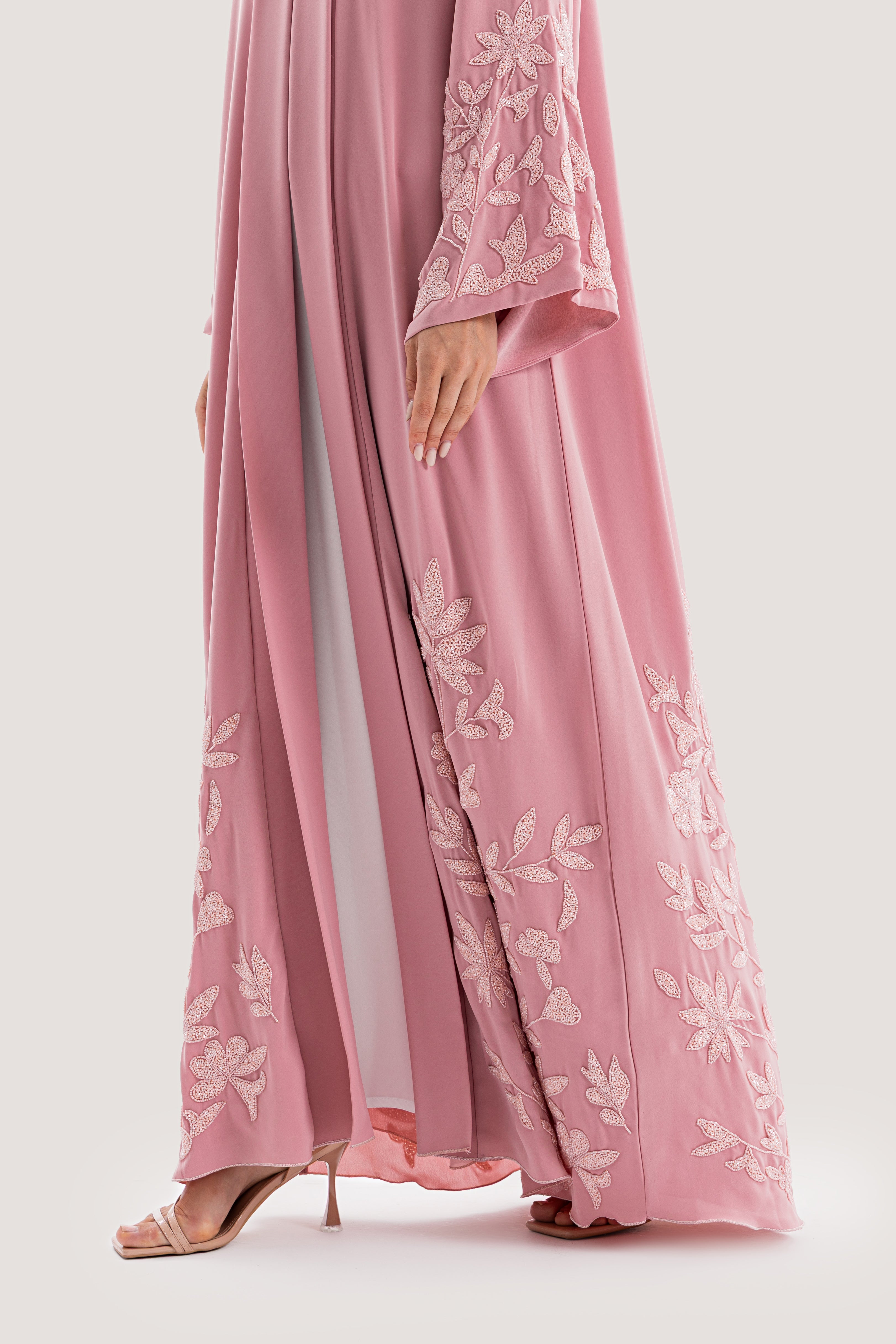Pink dress with floral embroidery on a white background